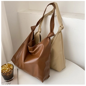 Detail view of large capacity tote bags with unique shoulder strap knot and PU leather texture