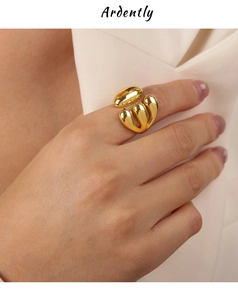 Close-up of gold layered liquid metal ring with organic droplet design worn on finger