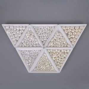 Detailed view of assorted oval ABS imitation pearls in triangular trays for DIY jewelry