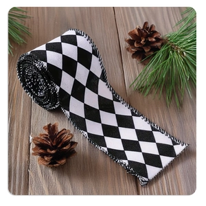 Close-up of black and white lattice linen ribbon on wooden table with pine cones