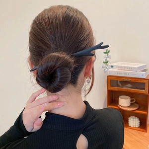 Détail du pic à cheveux bois de cerf noir avec glands de muguet porté sur un chignon