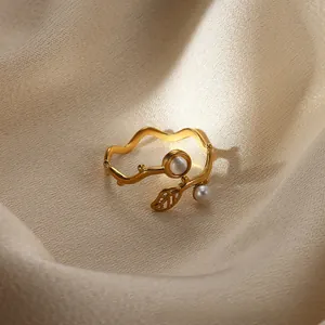 Detail of gold-plated wave ring featuring delicate leaf motif and white pearls