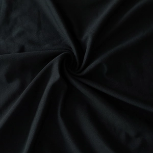 Gros plan sur la texture du tissu noir doux avec drapés en spirale pour robe de soirée