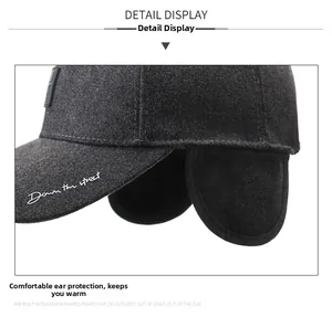 Detail of dark grey winter baseball cap with earflaps and Down the street embroidery