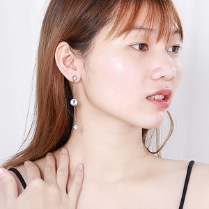 Elegant silver long tassel earrings with three sparkling round zircons worn by model