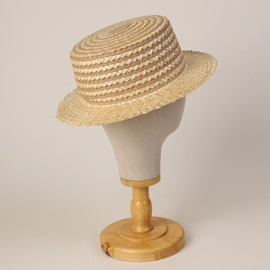 Détail macro du chapeau de paille montrant la texture tissée en spirale et le bord plat