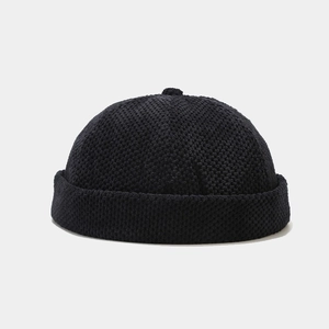 Detailed view of black knitted docker cap with heavy honeycomb texture and cuffed brim