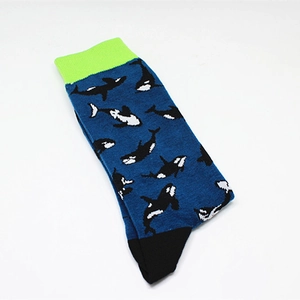 Detail of navy blue mid-calf sock featuring knit orca pattern and neon green ribbed cuff