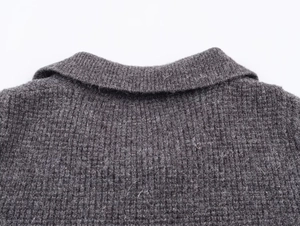 Detail of dark grey knit cardigan collar with ribbed edges and soft hairy texture