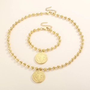 Detail of gold beaded necklace and bracelet set with St. Benedict coin pendants