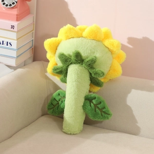 Vue détaillée du dos du coussin en peluche tournesol doux avec tige verte sur canapé