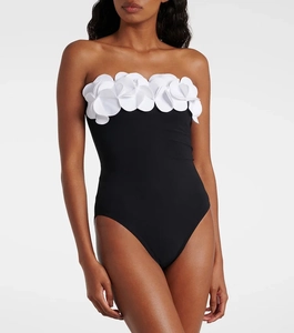 Detailed view of the 3D white floral embellishments on the black one-piece swimsuit