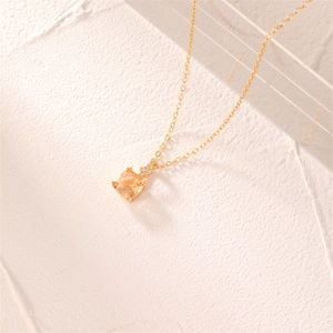 Minimalist gold necklace with a square orange zircon pendant in a warm light setting
