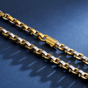Detail of two-tone gold and silver interlocking chain necklace with cylindrical clasp