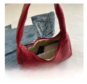Detail view of red woven hobo bag interior showing capacity for lipstick and coin pouch