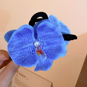 Detail of blue orchid fabric hair tie with a central white pearl and natural texture