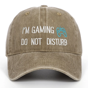 Detail of embroidered 'I'M GAMING' text and gamepad icon on washed cotton baseball cap