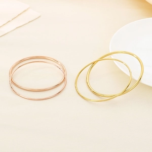 Macro shot of minimalist gold and rose gold stainless steel round bangle bracelets