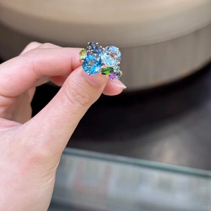 Detail of colorful gemstone cluster ring with blue and purple stones on gold band