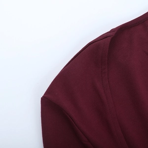 Dettaglio dello scollo quadrato e delle cuciture sulla spalla di un top in maglia bordeaux