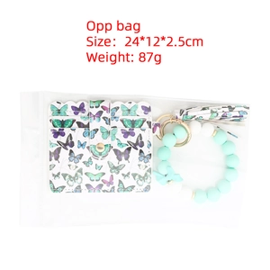 Détail du portefeuille à motif papillon et porte-clés perlé sous emballage scellé