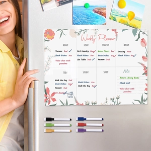 Detailed view of magnetic acrylic weekly planner with floral patterns on a fridge