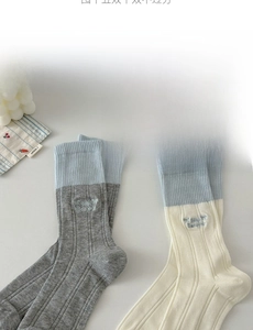 Detail of knitted cotton socks featuring Bebe Bonjour embroidery and contrast ribbed cuffs