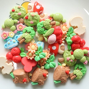 Close-up of mixed resin flower, mushroom, and tree charms for DIY hair clips and crafts