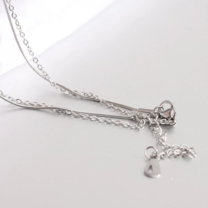 Dettaglio di una collana a due strati in argento con catena snake e chiusura a moschettone
