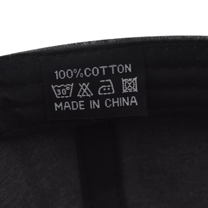 Macro view of the 100% cotton wash label and care instructions inside the baseball cap