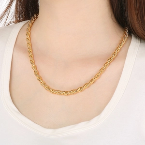 Vue détaillée d'un collier en chaîne torsadée en acier inoxydable doré porté par un modèle