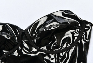 Close-up detail of glossy black faux leather bodysuit with structured underwire cups