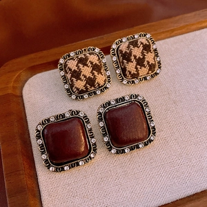 Close-up of vintage square earrings featuring houndstooth and wine red resin textures