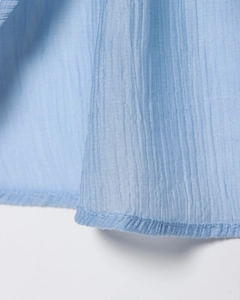 Vue détaillée du tissu en maille plissée bleu clair avec fines textures verticales