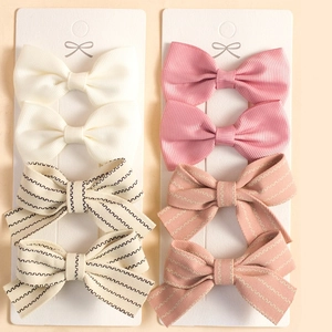 Detailed view of 8-piece striped bow hair clips set on display cards for girls