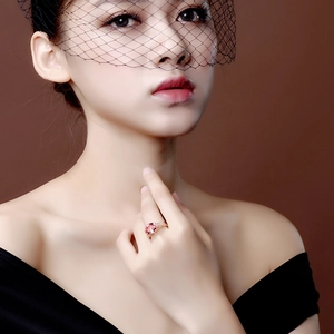 Pink oval gemstone ring in rose gold finish worn by model with black mesh veil