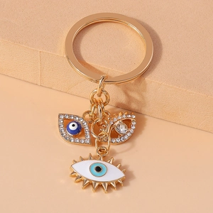 Golden Evil Eye keychain with rhinestone embellishments and blue enamel pendants