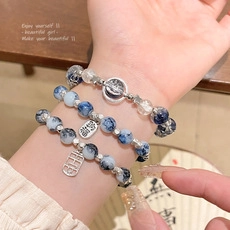 Detailed shot of beaded bracelets with marble texture and silver blessing charms