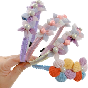 Handheld display of floral mesh headbands with pearls in purple, pink and yellow tones