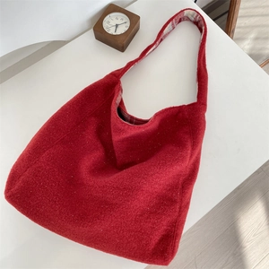 Detail of red plush hobo tote bag featuring soft fleece texture and red plaid inner lining