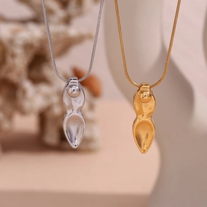 Gros plan de pendentifs abstraits minimalistes or et argent sur des chaînes serpent
