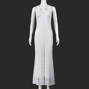 Détail de la texture en dentelle et du col en V sur la robe blanche sans manches
