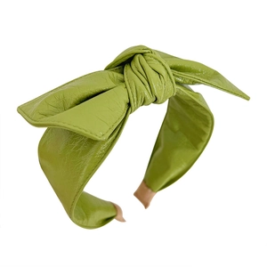 Glossy green faux leather bow headband with textured finish and non-slip tip covers