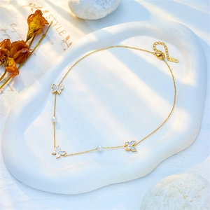 Elegant gold titanium chain necklace with pearl accents and mother-of-pearl butterflies