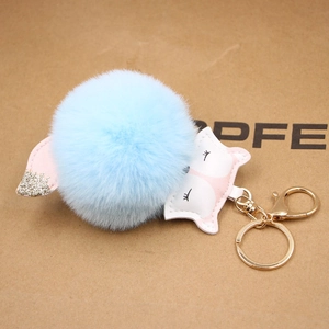 Detail of blue faux fur fox keychain with pink ears and gold-tone metal hook