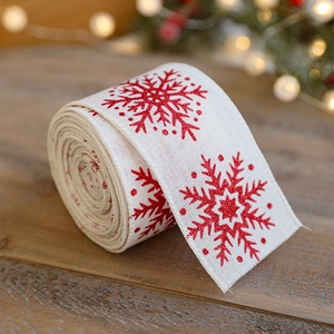 Christmas burlap ribbon with red glitter snowflakes on wooden background