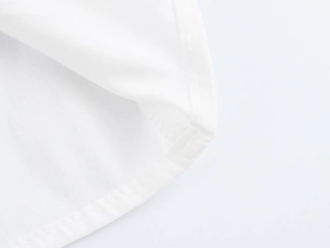 Macro shot of precise stitching and premium white cotton fabric texture on shirt hem