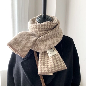 Detail of brown and beige knitted scarf showing houndstooth texture and Nice To Meet label