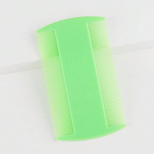 Macro detail of a light green double-sided flea comb for pets with fine plastic teeth