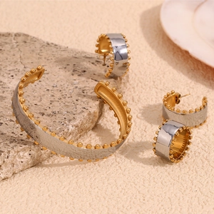 Two-tone stainless steel jewelry set with beaded edges on a wide bangle and hoop earrings